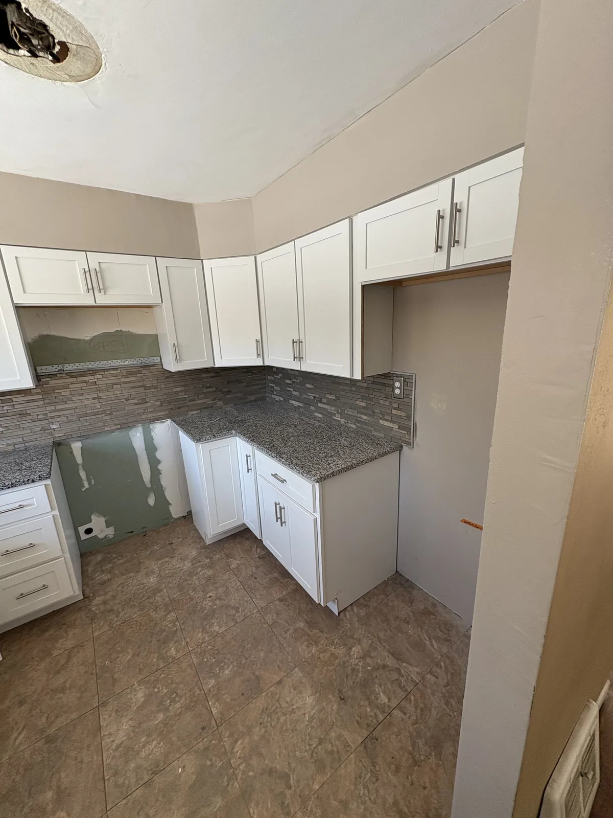 White cabinets and stone counters in the Scottdale kitchen, a L.A. Builds project